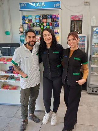 Tres integrantes de Proteger Salud con uniformes institucionales dentro de la sucursal; dos usan uniforme negro del sector perfumería y uno uniforme blanco del sector farmacia.