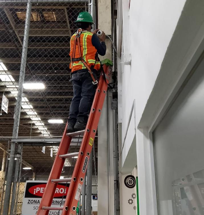 Técnico especializado realizando instalación de cableado estructurado y canalización industrial en proyecto de seguridad electrónica