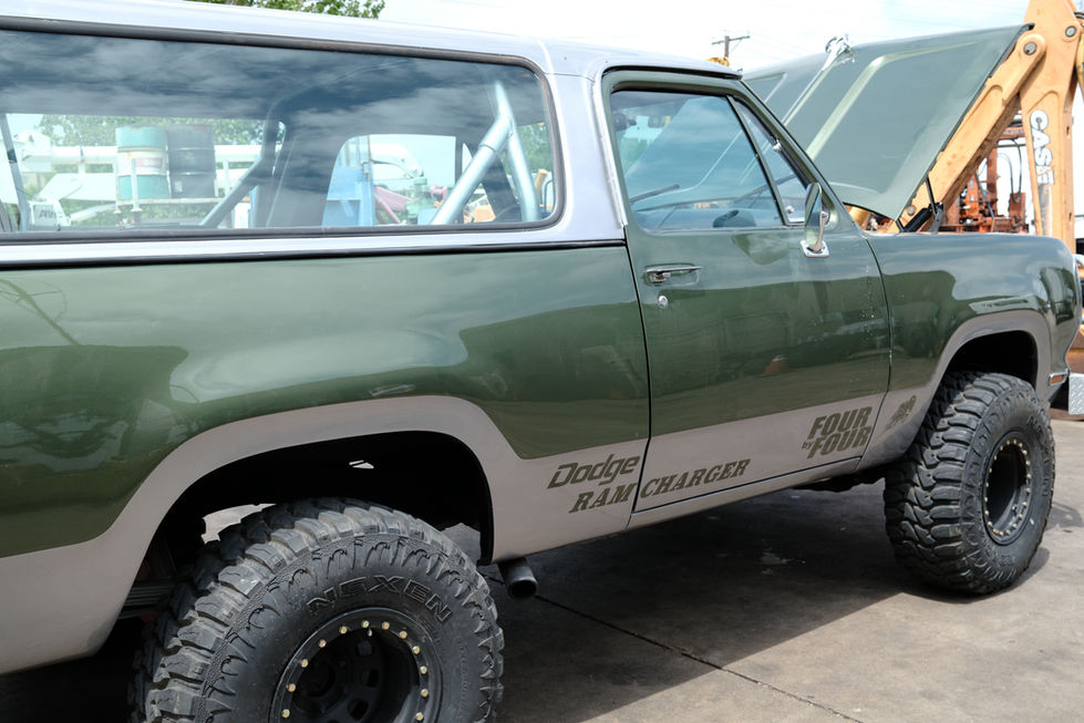 Green off-road vehicle with large tires.