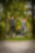Zwei Personal Trainerinnen springen in einem Park vor Freude in die Luft