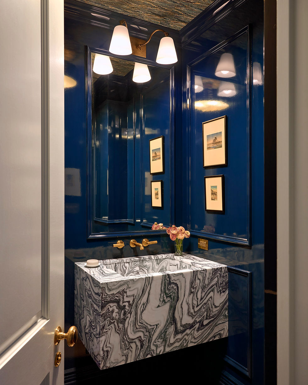 Custom double vanity with marble countertop, elegant sconces, and built-in storage in a luxury bathroom remodel.