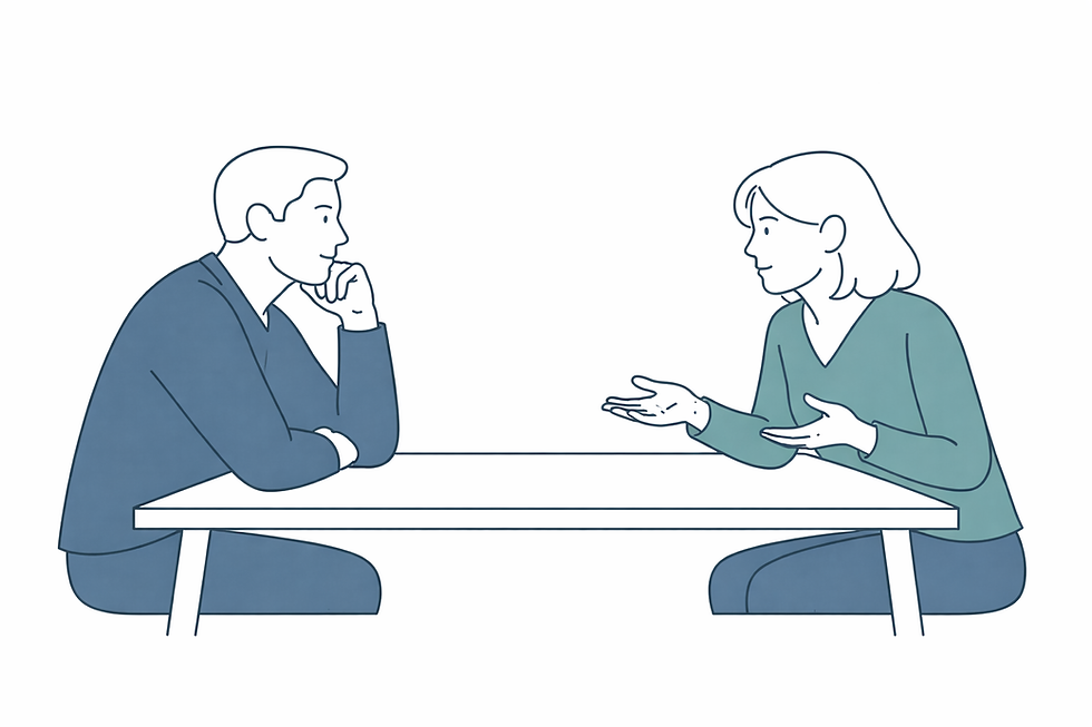 Two colleagues seated across a table in a thoughtful one-on-one conversation.