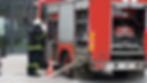 A firefighter in full protective gear operates fire truck equipment during an emergency re