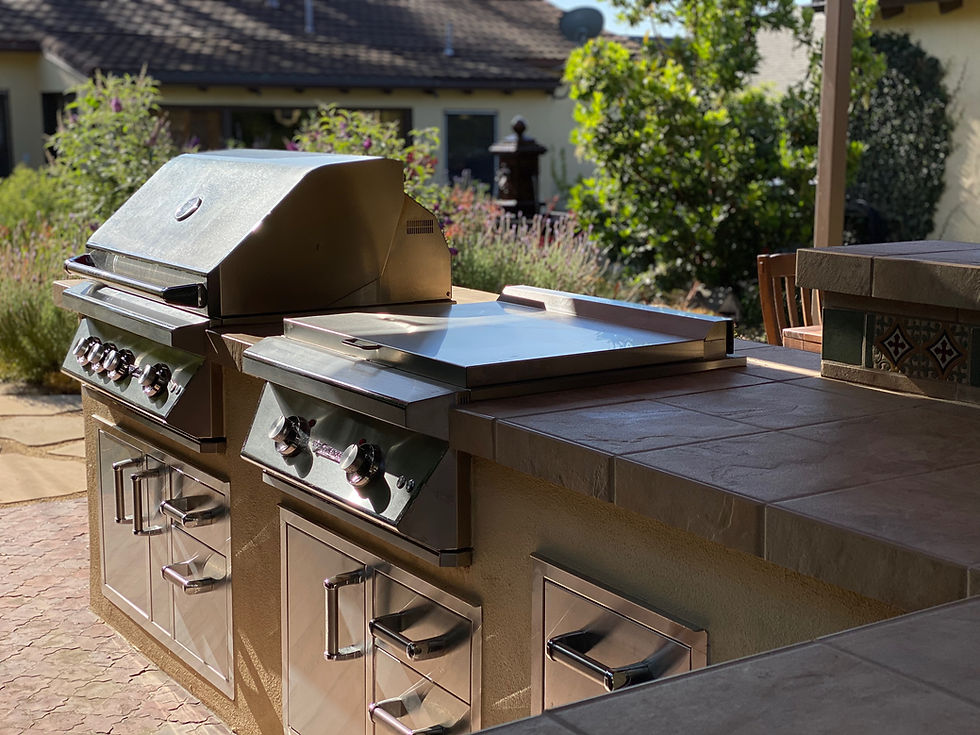 Outdoor kitchen design Pasadena with built in grill, counter seating, and pergola shade structure for entertainment