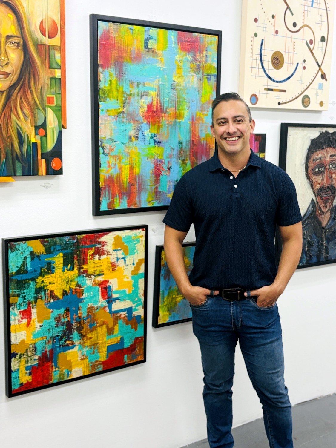 Edward in a navy polo in front of Movimiento paintings