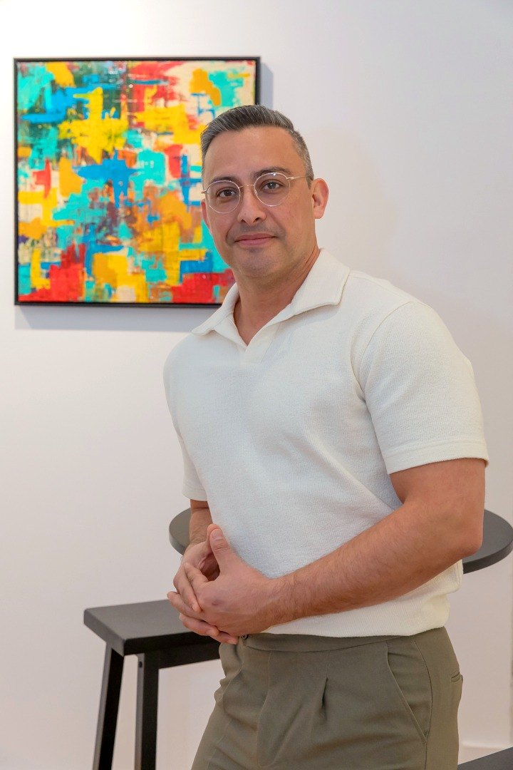 Edward leaning on a stool beside his paintings