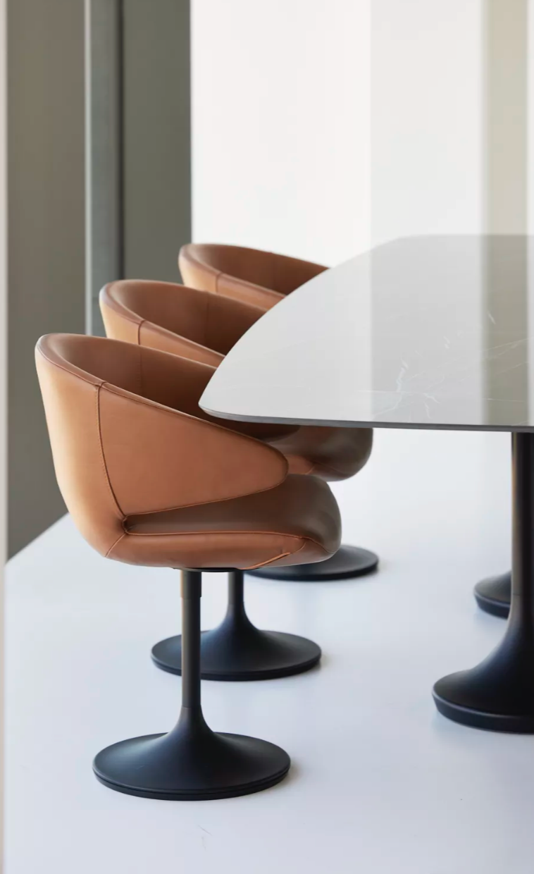 tan upholstered dining chair round a table with central base