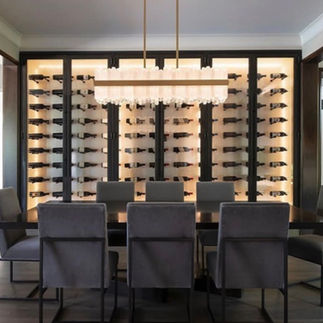 Lior art glass rectangular pendant above a dining table with wine cooler display behind