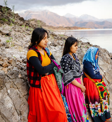 Huichol women dressed in colorful outfits at Lake Aguamilpa