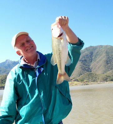 Man in blue coat and big largemouth bass