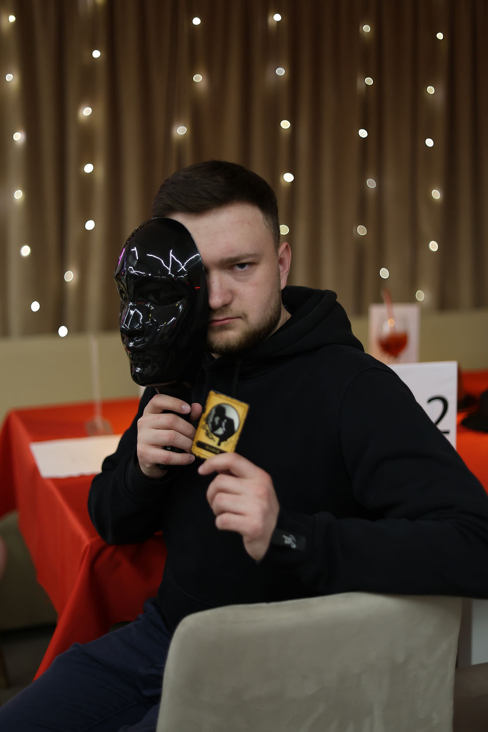 Гравець з картою та маскою під час гри мафія у Києві — живі ігри