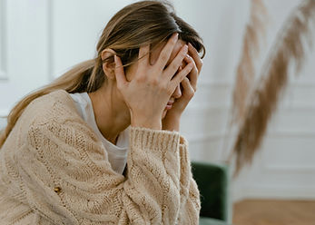 Picture of woman with her head in her hands from narcissistic or emotional abuse