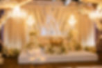 Elegant wedding stage with white flowers, lights and decorative elements in room