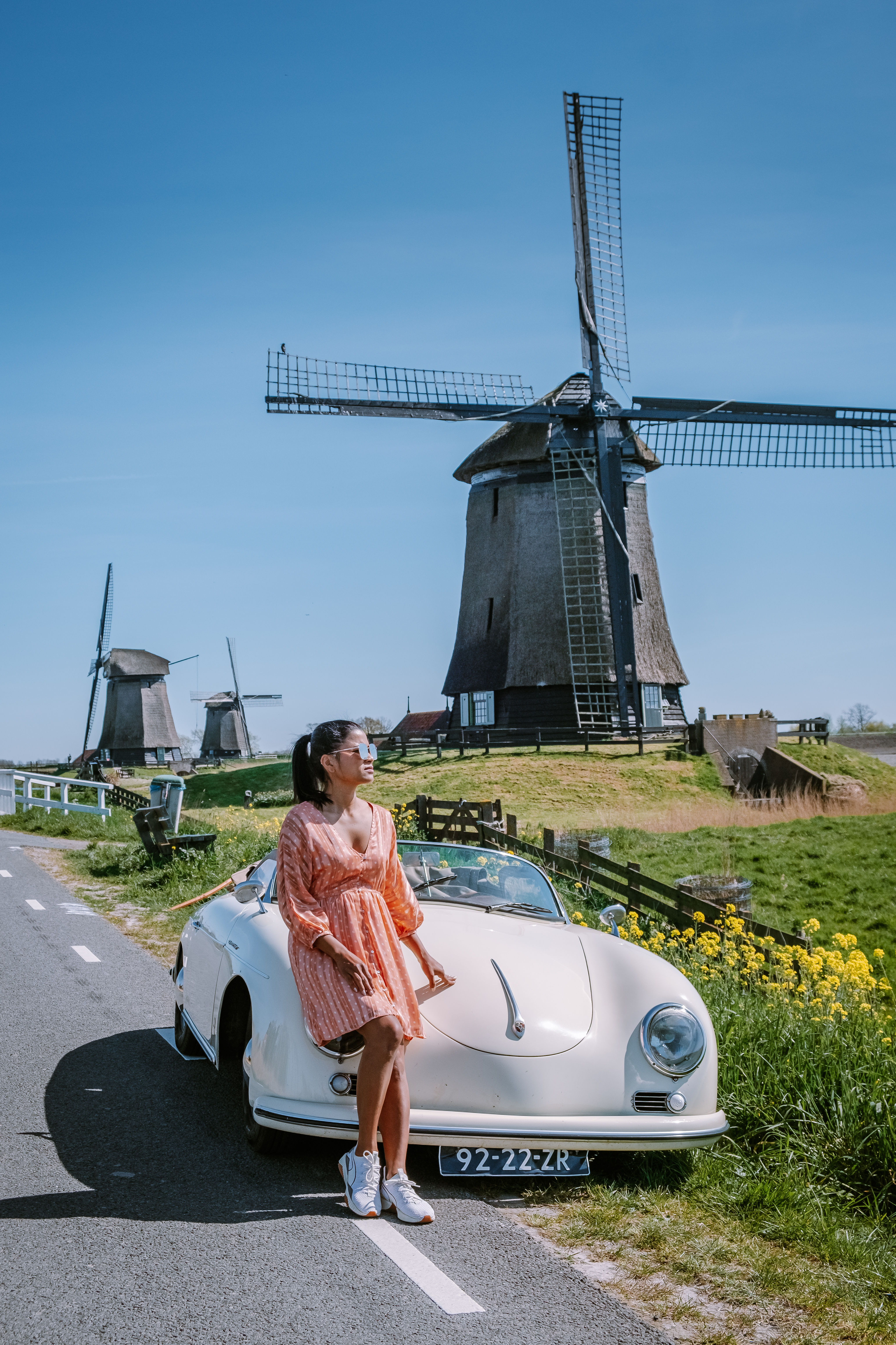 woman with a old classic car in front of a windmill at Schermerhorn Netherlands