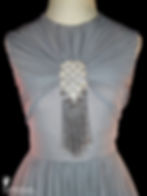 The sleeveless bodice of a vintage couture Art Deco gray silk chiffon floor-length evening gown with the fabric sewn in a radial gather around a large rhinestone and silver glass beaded tassel centerpiece.
