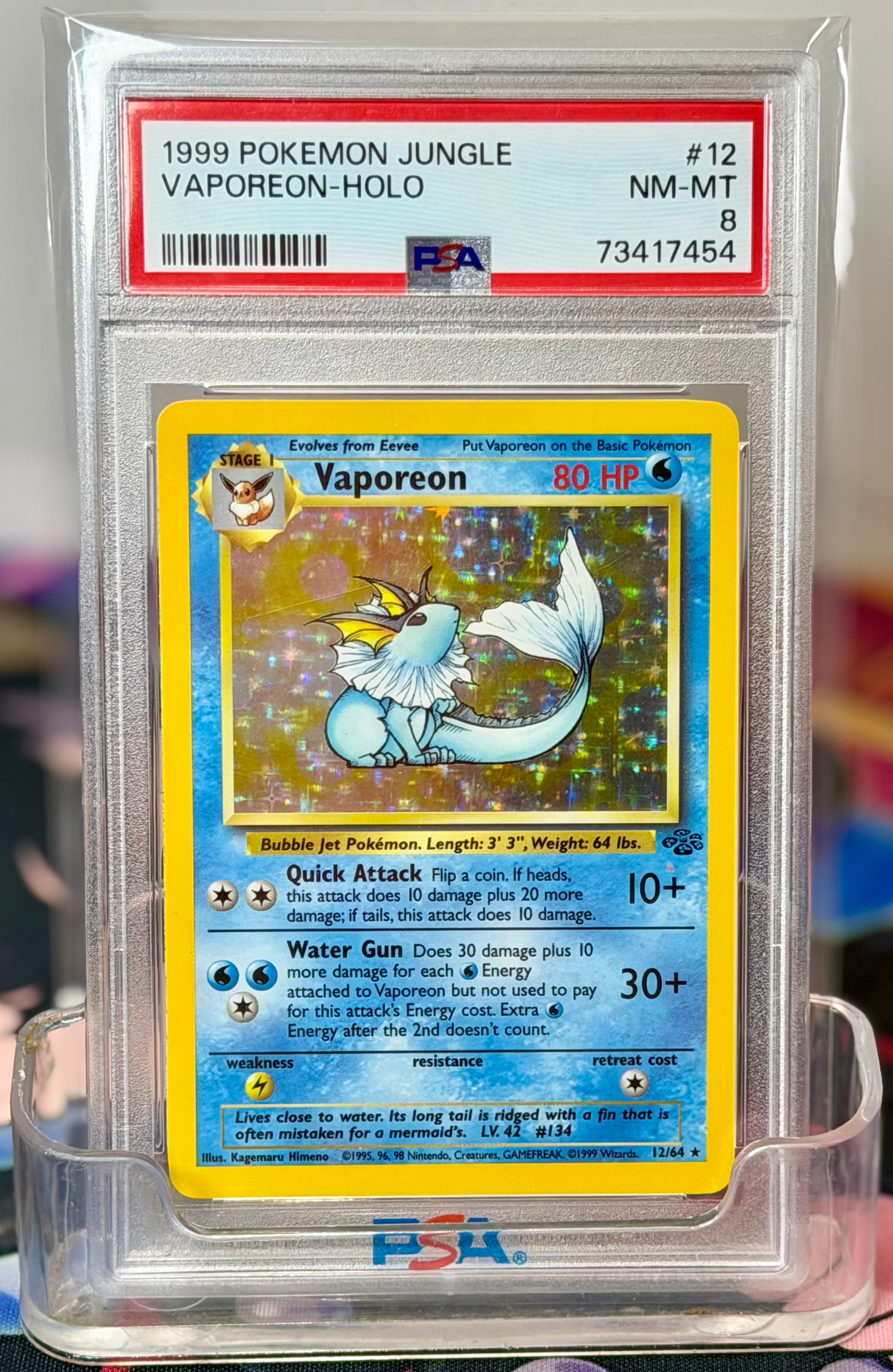 PSA 8 NM-MT 1999 Pokémon Jungle Vaporeon #12 holo, a vintage WOTC rare. This Pokemon Vaporeon from Jungle is PSA 8