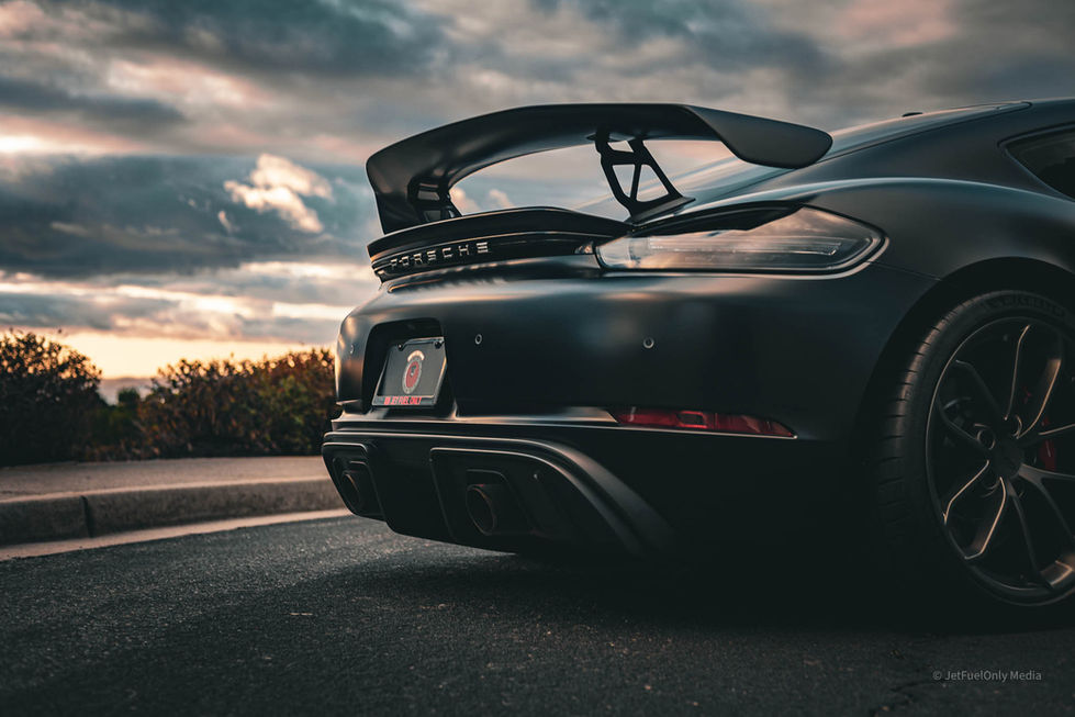 a black porsche is parked on the side of the road