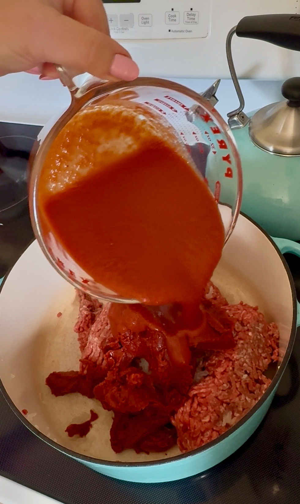 pouring tomato sauce into pan