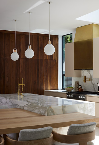 modern kitchen with brass hood and marble island