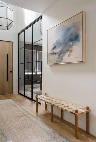 Elegant entry way with oversized soor and steel an dglass partition