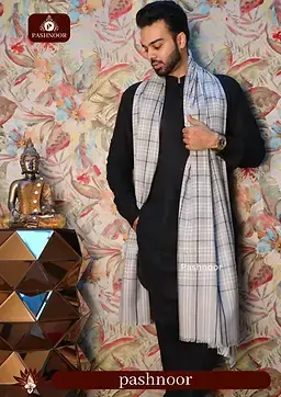 This image features a stylish man draped in a Pashnoor shawl, exuding elegance and sophistication. The shawl has a refined checkered pattern in soft, neutral tones, perfectly complementing his classic black outfit. The backdrop showcases a luxurious setting with floral wallpaper, a golden geometric table, and a Buddha statue, adding an artistic and serene touch to the composition. The Pashnoor branding is subtly displayed, emphasizing the premium quality and timeless appeal of the shawl. This image captures the essence of heritage, craftsmanship, and luxury fashion, making it a perfect visual for high-end branding.