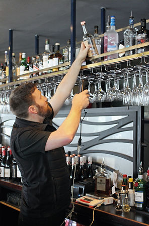 Stocktaker reaching for a bottle of spirits