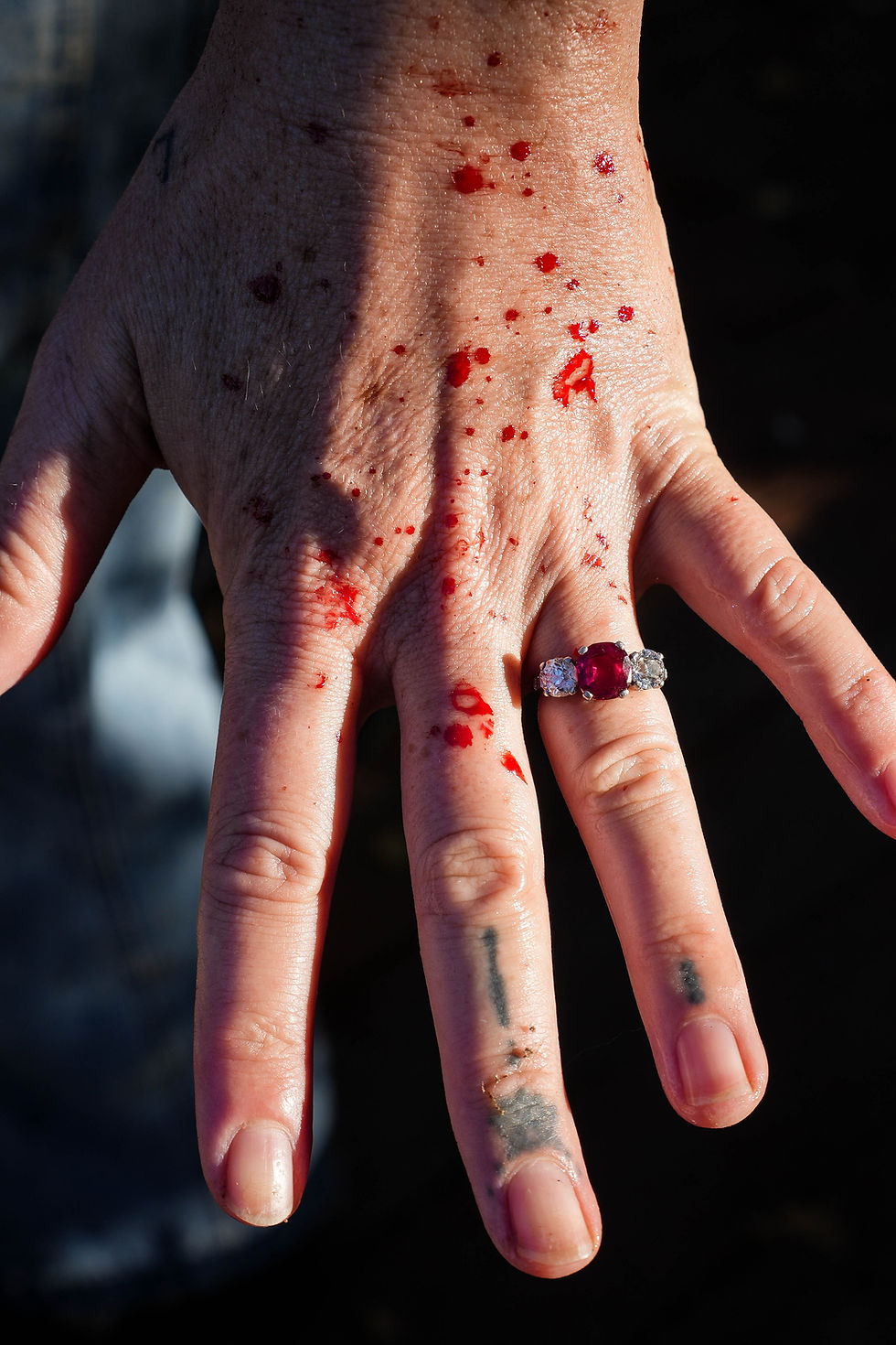 A bride's shows off her blood-speckled wedding hand and ruby-red engagement ring after all the birds have been processed for her spring wedding.