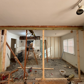 Open wall framing showing a newly installed heavy structural load-bearing beam header during home demolition.