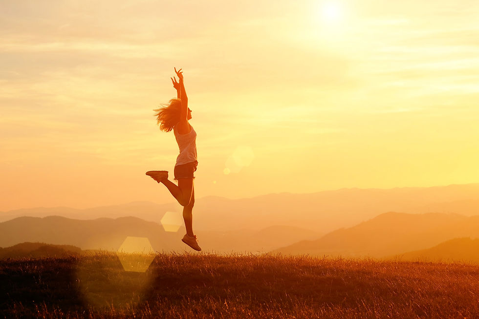 Woman joyously jumping at sunet out in nature.