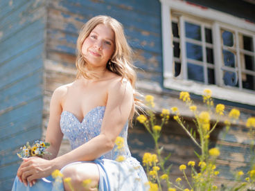 Graduation photo session of young graduate in beautiful sky blue dress