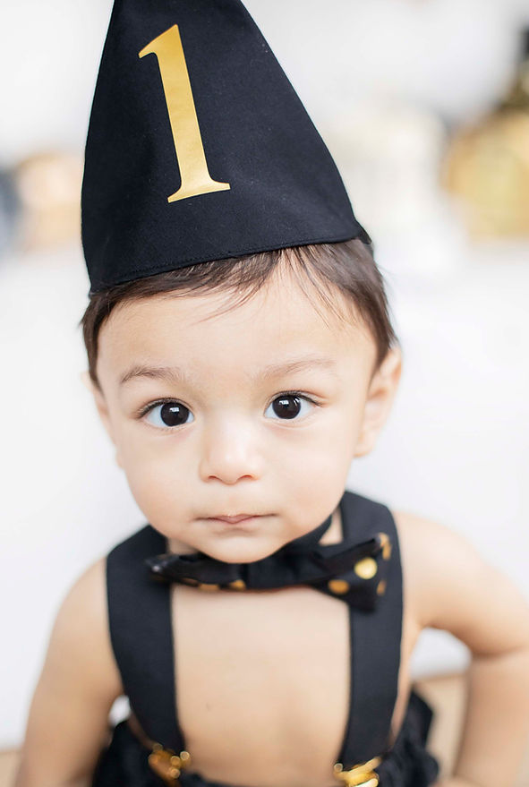 first birthday cake smash little boy black and gold decor close up
