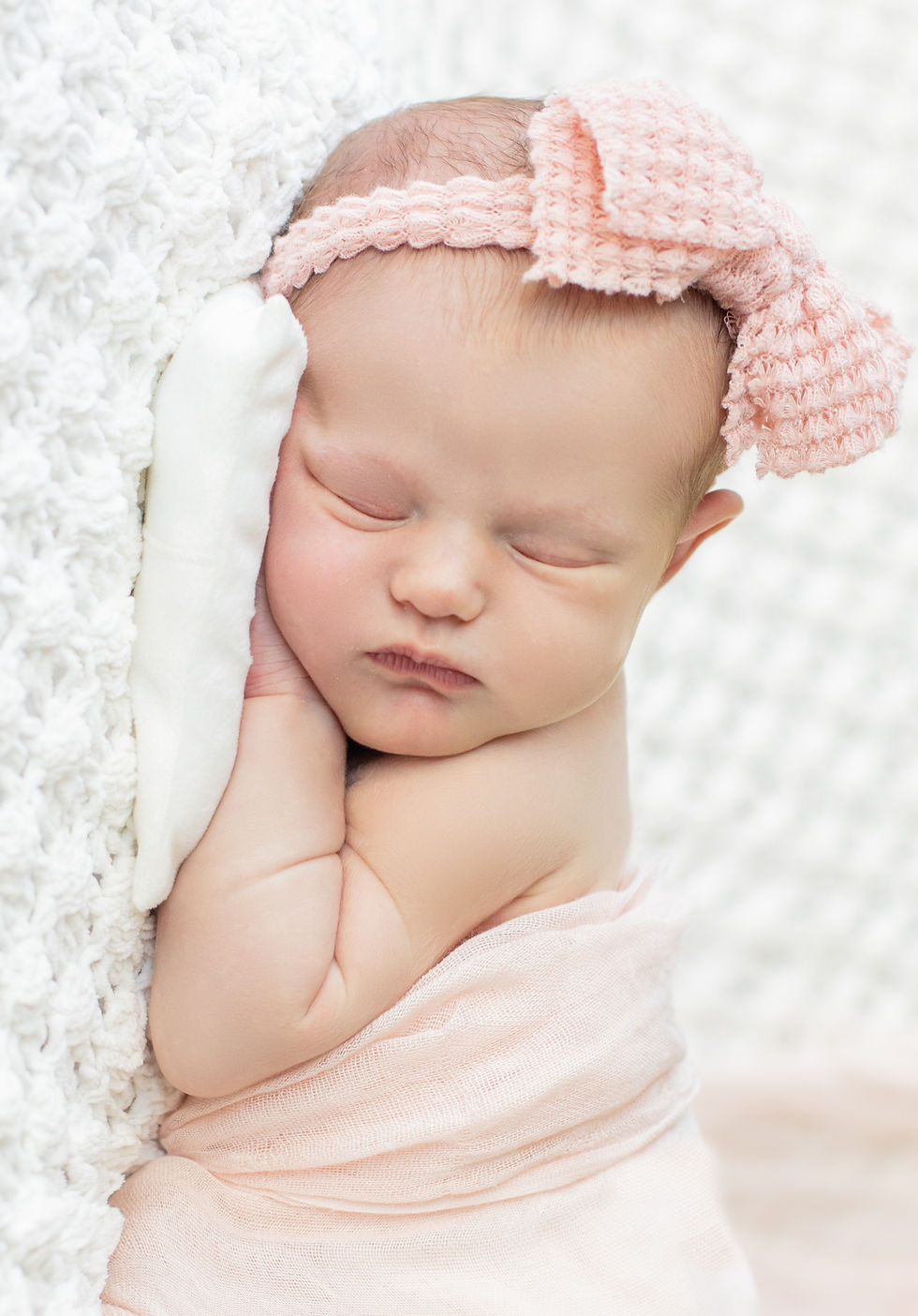 Tiniest Seattle Seahawks football fan Vancouver newborn photoshoot swaddled in ballet pink with pink bow close up