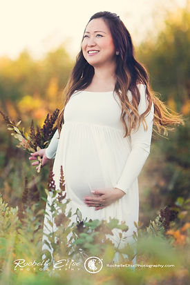 pregnant mom in white long dress in a sunflower patch