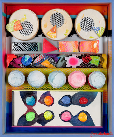 A wooden box containing sculpted models of chocolate pralines cakes and candy arranged aesthetically in horizontal rows.