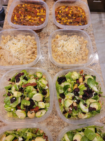 Picture of 8 meals prepared and laid out for the week in their containers. 