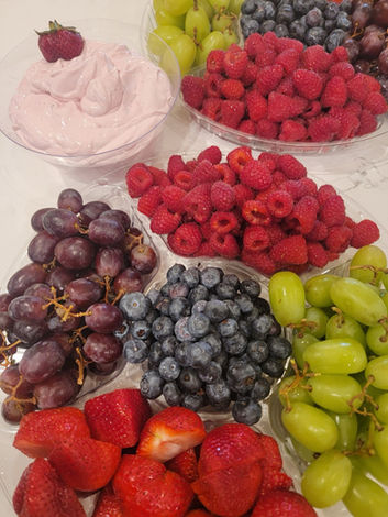 Picture of a fruit platter including strawberries, blueberries, green grapes, purple grapes and raspberries. 