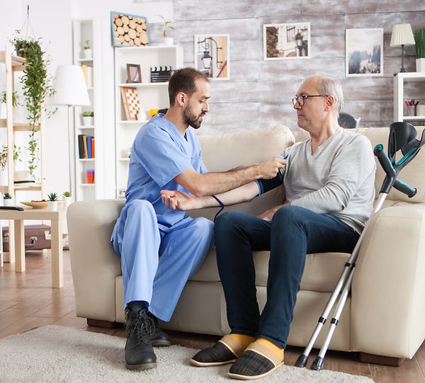 caucasian-young-doctor-nursing-home-checking-blood-pressure-elderly-age-male-with-crutches