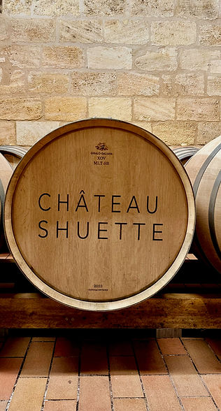 Wooden wine barrel engraved with Chateau Shuette logo against stone wall representing natural wine category.