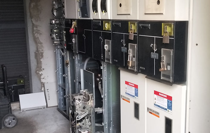 Maintenance d'un tableau de cellules haute tension SM6 de Schneider Electric, avec un technicien vérifiant les composants pour assurer performance et sécurité.