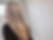 Back view of long silver hair with remaining blonde ends during the final stages of growing out hair color in warm lighting
