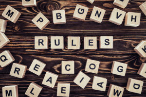 top view of rules word made of wooden blocks on brown surface