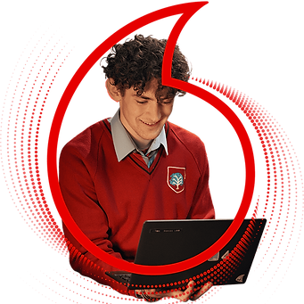 school boy smiling at laptop inside a vodafone logo