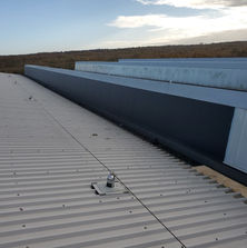Long bank of windows half covered with black vinyl and half still clear to show the comparison between them