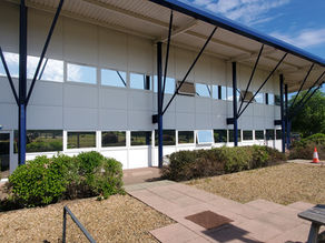 Office building suffering from solar heat gain with a reflective heat reduction window film on the windows