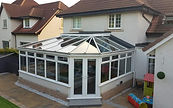 Large conservatory with reflective heat reduction window film installed on the roof, windows and doors