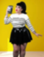 latex skating skirt with front buckle detailing worn with striped top