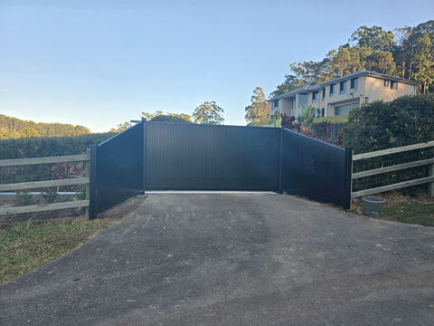 A custom metal fabricated bridge over a concrete surface with views of a building.