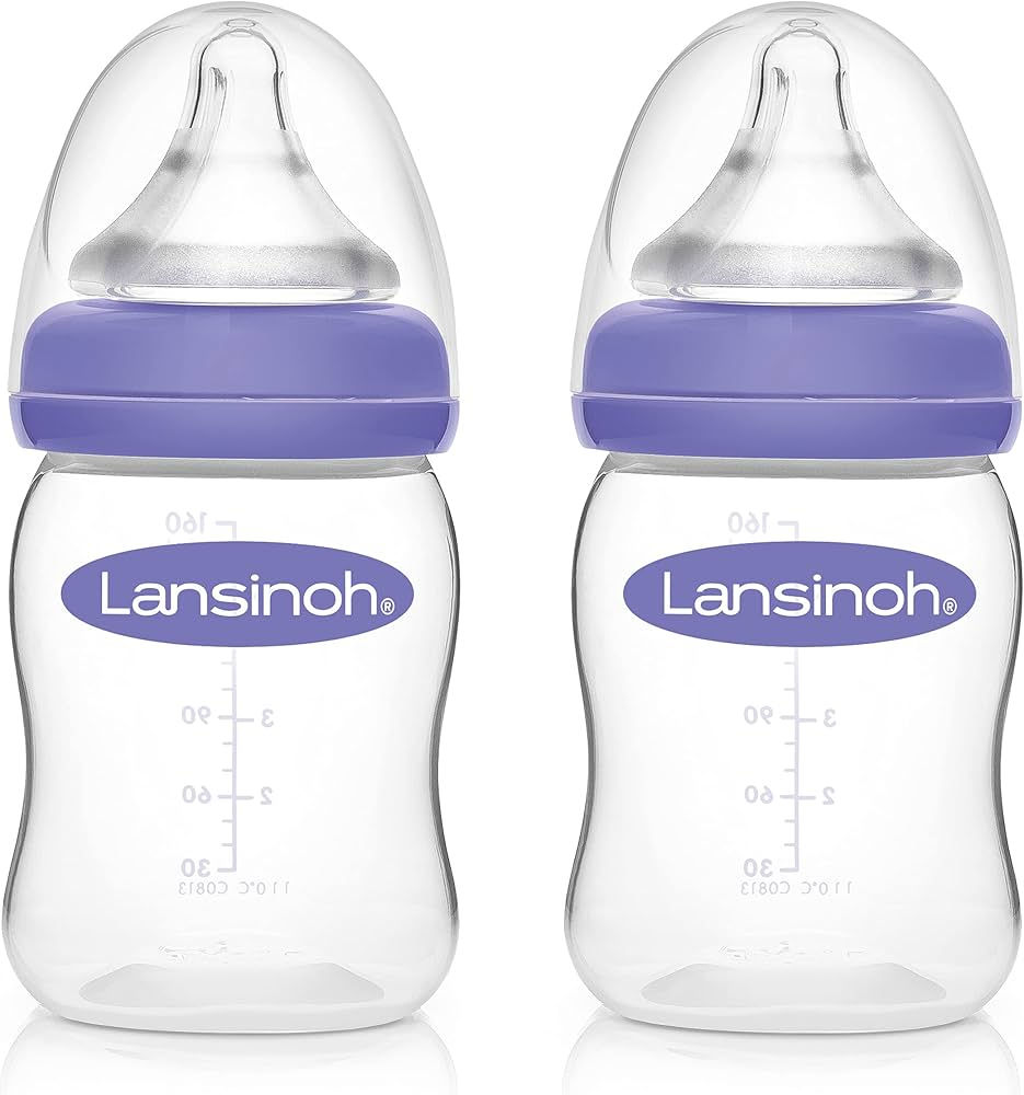 Two clear Lansinoh baby bottles with purple caps and nipples on a white background, shown side by side.