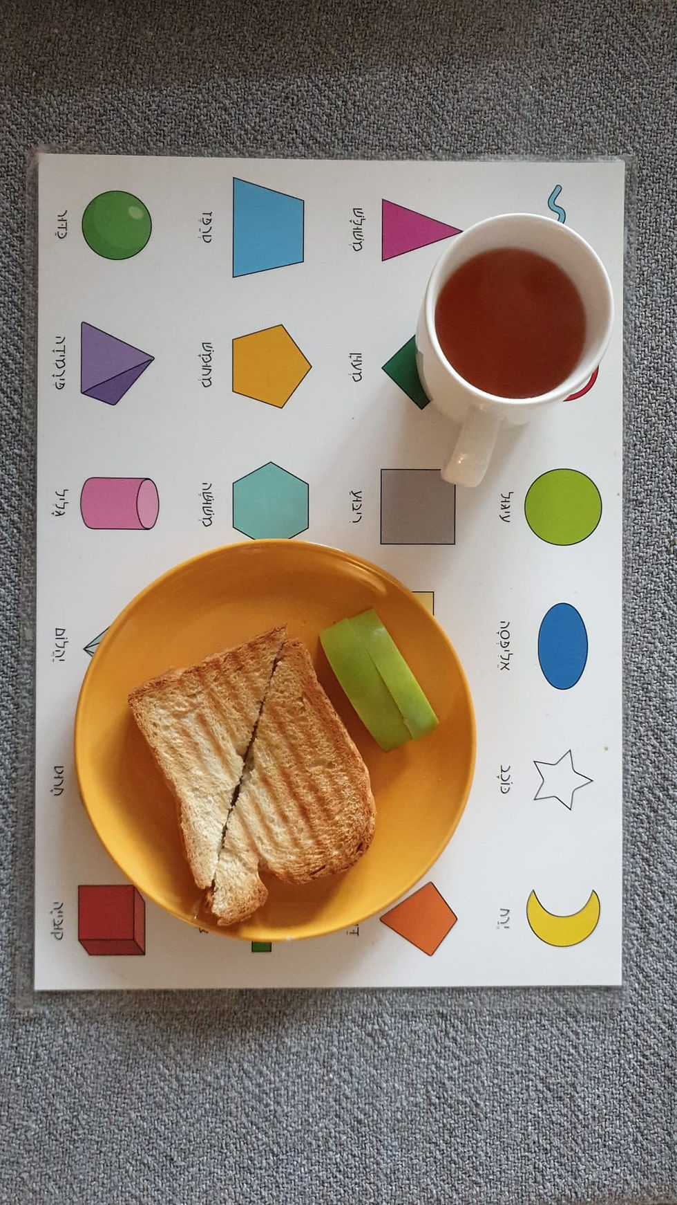 תמונה ממוזערת: צלחת עם אוכל על פלייסמט צורות הנדסיות