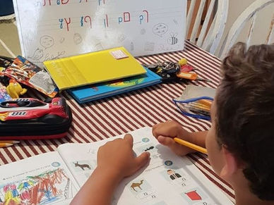 ילד מכין שיעורי בית ונעזר בפלייסמט הלימודי